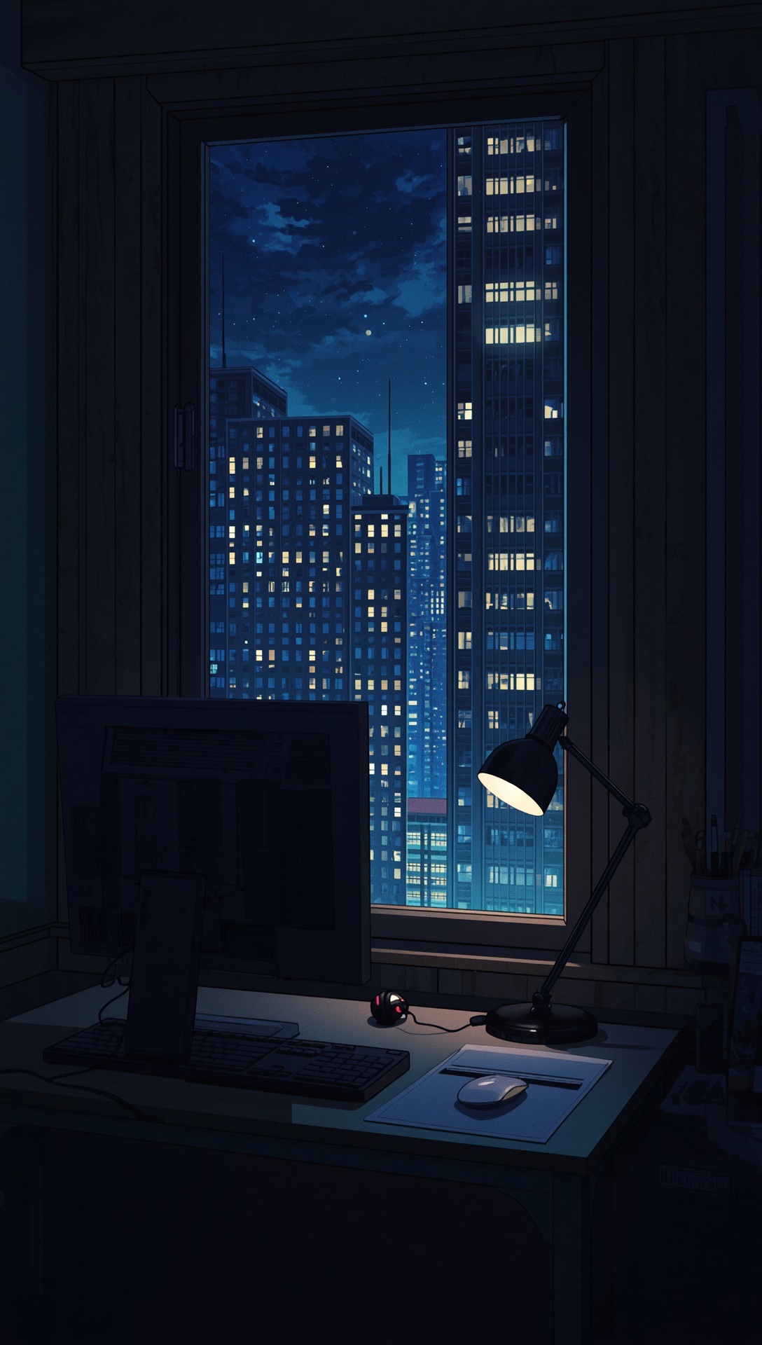 A desk lamp and a monitor in a dark room, lit skyscrapers through the window
